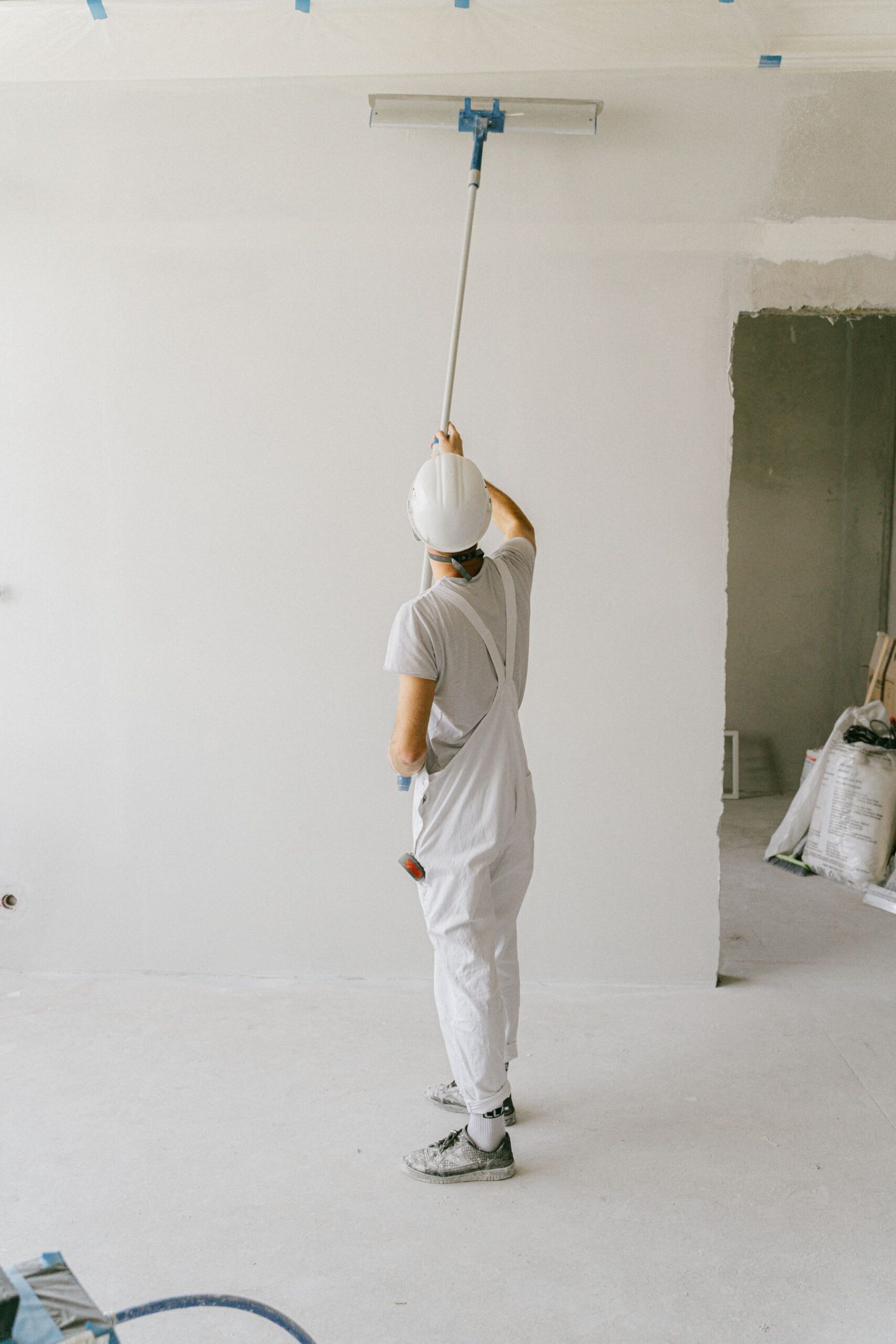 Decorator painting an interior wall with a roller